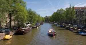 A panorama of 4 segments of an Amsterdam canal in summer.