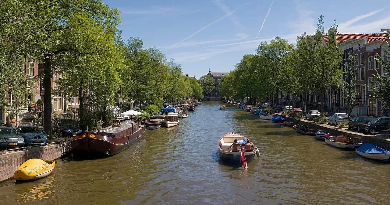 A panorama of 4 segments of an Amsterdam canal in summer.